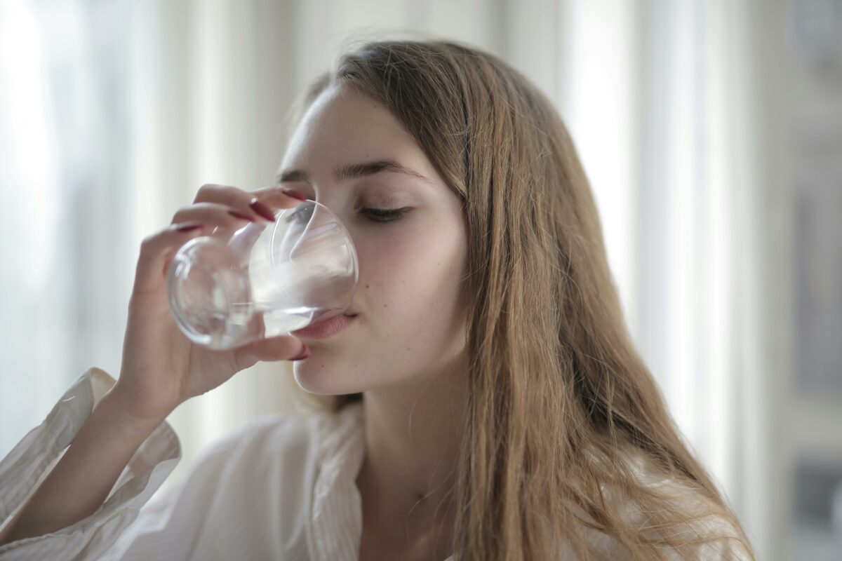 girl drinking water to prevent a uti